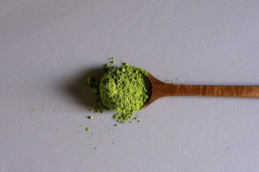 Wood spoon full of kratom powder